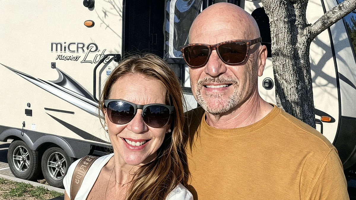 Fred and Rosane smiling in front of their Micro Lite travel trailer